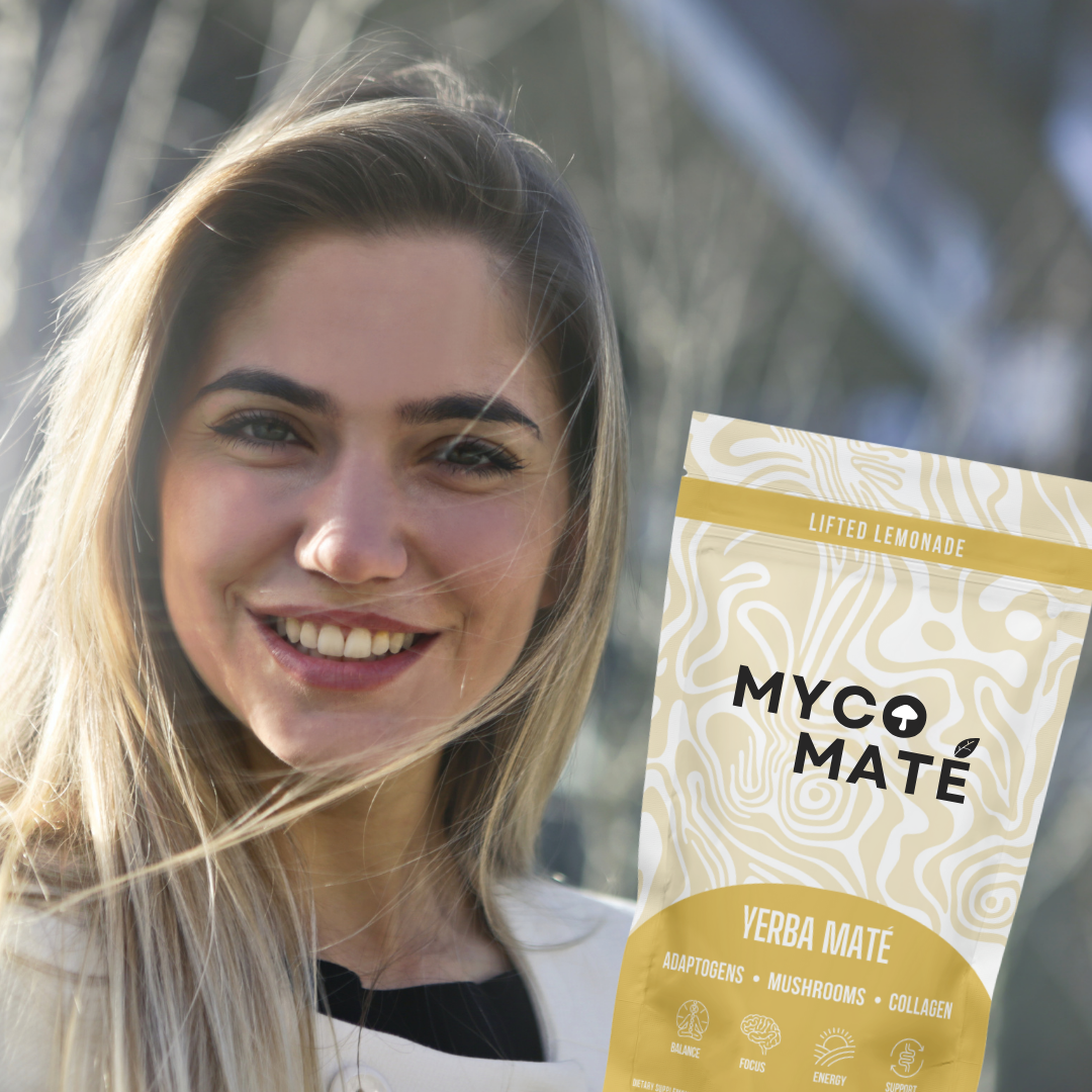 Smiling person holding MycoMaté Lifted Lemonade yerba maté drink mix with mushrooms, collagen, and adaptogens.